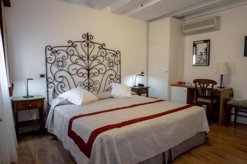 a bedroom with a large bed with a large headboard at Hotel Antigo Trovatore in Venice