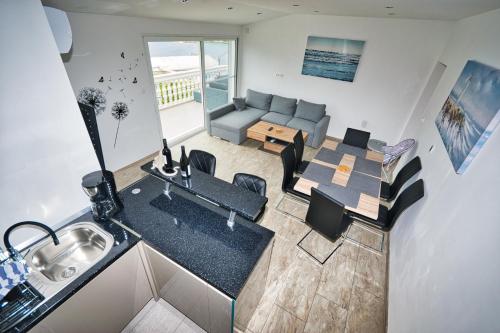 a kitchen and living room with a table and a couch at Vila Punta in Stomorska