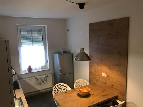 eine Küche mit einem Holztisch und einem Kühlschrank in der Unterkunft Zum Notar in Brand-Erbisdorf
