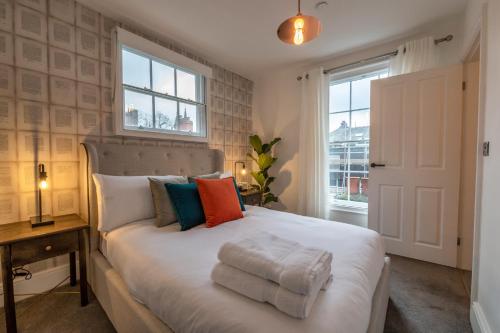 a bedroom with a large white bed with colorful pillows at Contemporary Apartment on the Historic Rows in Chester