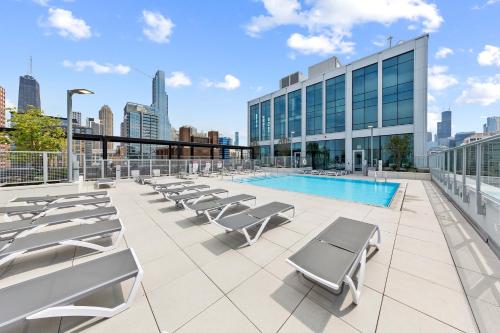 a pool on the roof of a building with lounge chairs at Kasa River North Chicago in Chicago