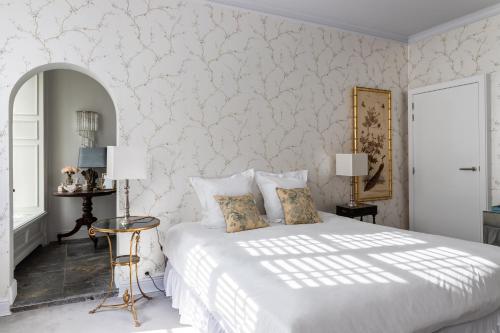 a bedroom with a white bed and a wall at Molenmeers Boutique Guesthouses in Bruges