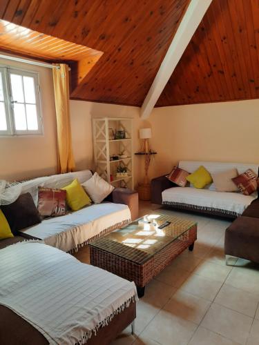 a living room with two couches and a coffee table at GÎTE Le Calou Pilon in Cilaos