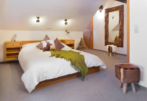 sypialnia z dużym łóżkiem i dużym lustrem w obiekcie Alpenhotel Bödele - Luxus Suite 02 w mieście Schwarzenberg
