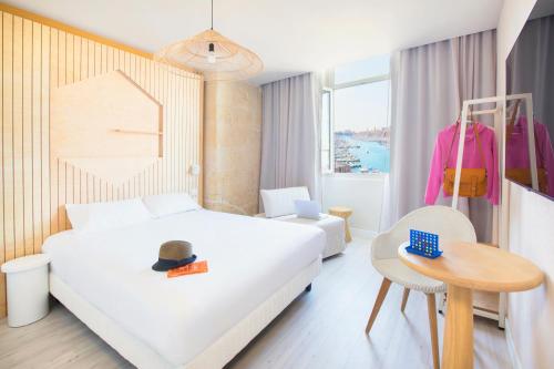Hôtel Life Marseille VP - Vieux Port في مارسيليا: غرفة في الفندق مع سرير وقبعة على طاولة