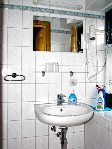 a white bathroom with a sink and a mirror at Ihrgistern, FW 2 in Zingst