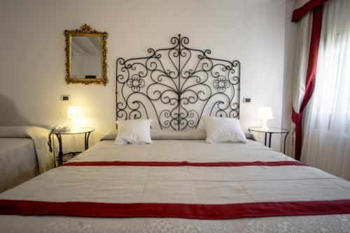 a bedroom with a large bed with a metal headboard at Hotel Antigo Trovatore in Venice