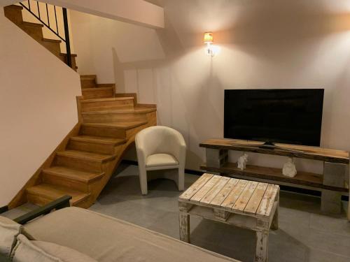 un soggiorno con TV, tavolo e sedia di Casa Las Margaritas a San Carlos de Bariloche