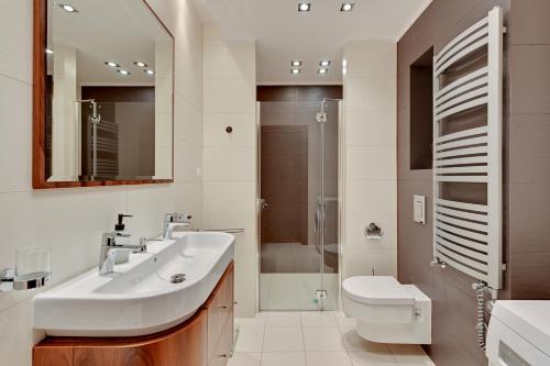 a bathroom with a sink and a toilet and a shower at Luxury Willa Morska by Grand Apartments in Sopot
