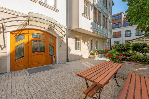 a wooden bench in front of a building with a door at Luxury Willa Morska by Grand Apartments in Sopot