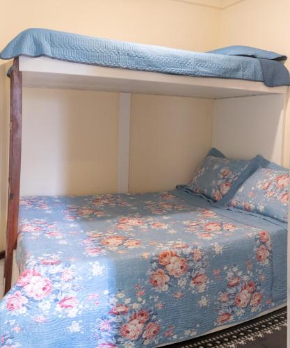 a bedroom with a bunk bed with a blue comforter at Apart vitória in Feira de Santana