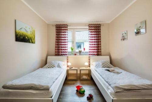 1 dormitorio con 2 camas y ventana en Wellness - Bungalow Strandgut en Klausdorf