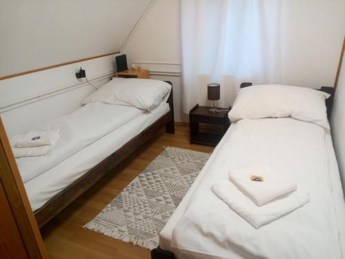 two beds in a small room with a window at Krisztina Apartman 2-3 in Szigethalom