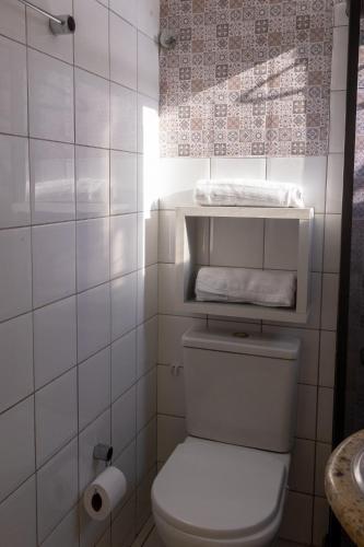 a white bathroom with a toilet and a sink at Apart vitória in Feira de Santana