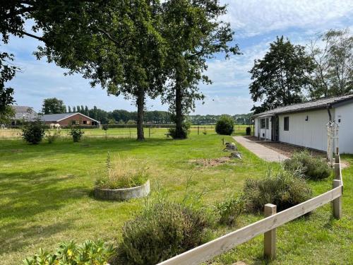 um quintal com uma cerca e uma casa branca em De Bargsche Hoeve em Azewijn