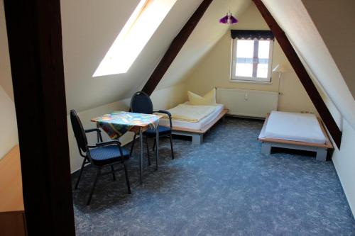 ヴェルニゲローデにあるFerienwohnung 1 - 26713のベッド2台、テーブル、椅子が備わる客室です。