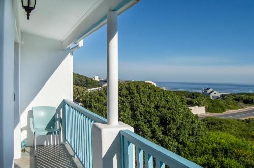 a porch with a chair and a view of the ocean at Bellamente Sirene in Gansbaai