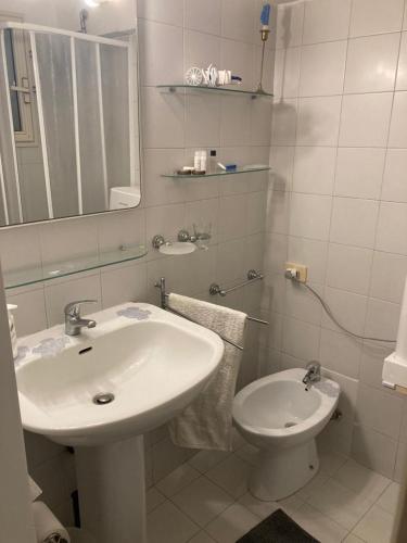 a white bathroom with a sink and a toilet at MELLINI HOUSE in Rome