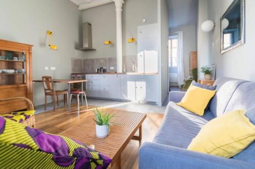 a living room with a blue couch and a table at La Chassagne, en plein cœur de ville in Dijon