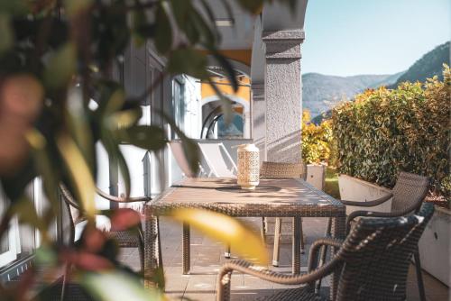 a wooden table and chairs on a patio at Yachting Residence in Lavena Ponte Tresa