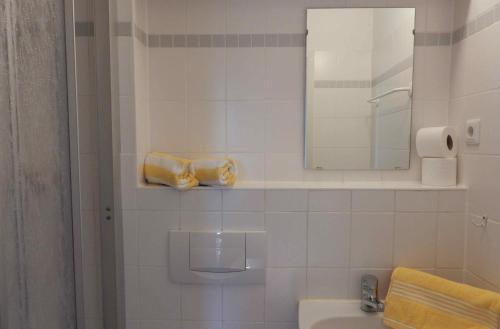 プレローにあるResi K5の白いタイル張りのバスルーム(シンク、鏡付)