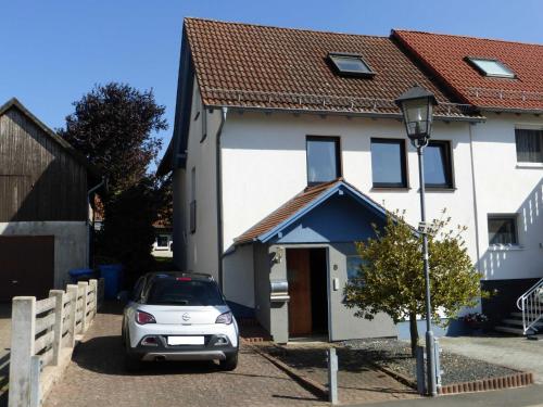 a car parked in front of a white house at Zum Roemernest in Würzberg