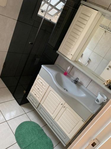 a bathroom with a white sink and a mirror at Blue Hale in Guarujá