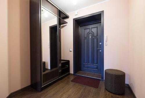 a hallway with a blue door and a mirror at Apart Petrovskie on Sovetskaya 69 in Tomsk
