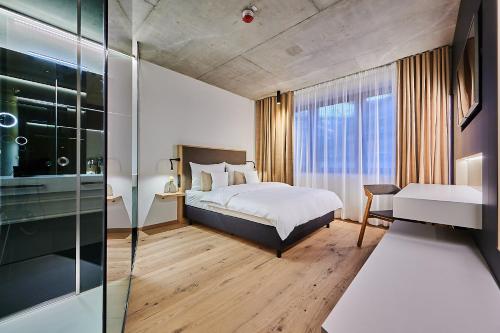 a bedroom with a bed and a large window at Villa Boutique Hotel in Straubing