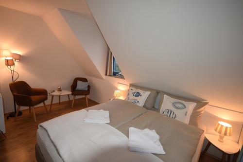 a bedroom with a bed with white sheets and pillows at Ostseebrise FH 1 in Zingst