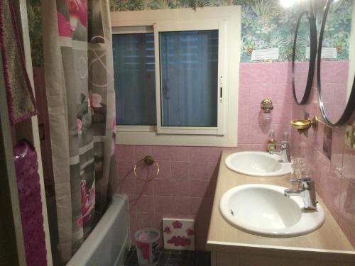La salle de bains est pourvue de 2 lavabos, d'une fenêtre et d'une baignoire. dans l'établissement Villa Elisabeth Saint-Raphaël, à Saint-Raphaël