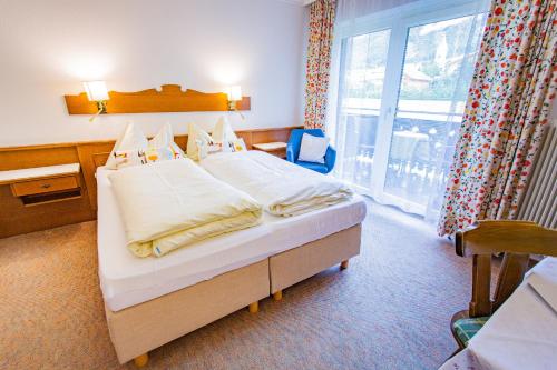 ein Schlafzimmer mit einem Bett und einem großen Fenster in der Unterkunft Soldanella 6 by Alpenidyll Apartments in Ramsau am Dachstein