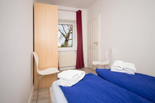 two beds in a room with blue sheets and white towels at Schleiblick App 3 in Rabenkirchen-Faulück