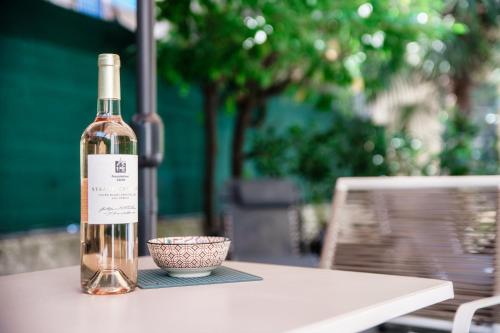 a bottle of wine and a bowl on a table at Spazio 77 - The House Of Travelers in Como