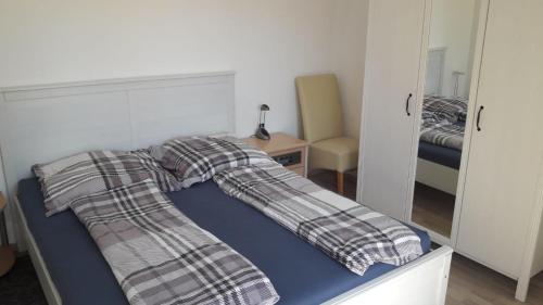 ein Bett mit einer Decke darauf in einem Schlafzimmer in der Unterkunft Ferienwohnung Max 2 in Grube