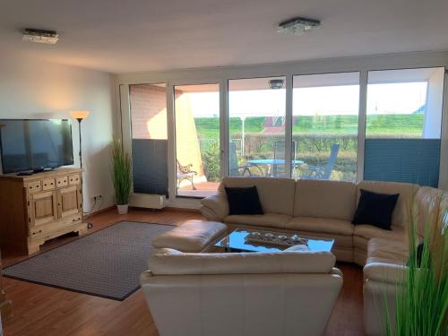 Il comprend un salon doté d'un canapé et d'une télévision à écran plat. dans l'établissement Apartment 45, à Wilhelmshaven