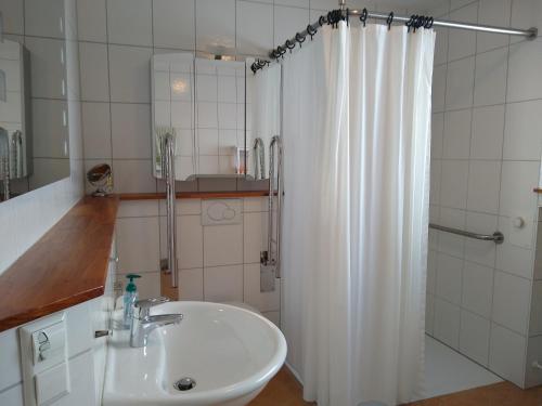 a bathroom with a sink and a shower curtain at Burgblick-Fewo Töpfer in Annweiler am Trifels