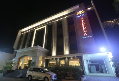 a car parked in front of a building with a sign at Hotel Stella Continental in Phagwāra