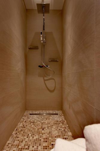 La salle de bains est pourvue d'une douche et de carrelage. dans l'établissement Au Hameau de l'Ecluse proche Europa-Park, à Marckolsheim