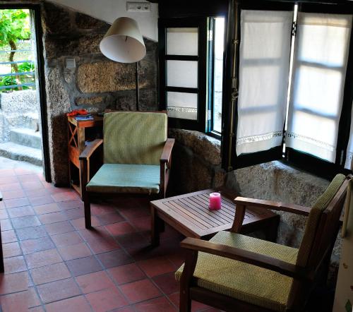 a room with two chairs and a table and a lamp at Casinha da Horta com Jacuzzi in Soajo