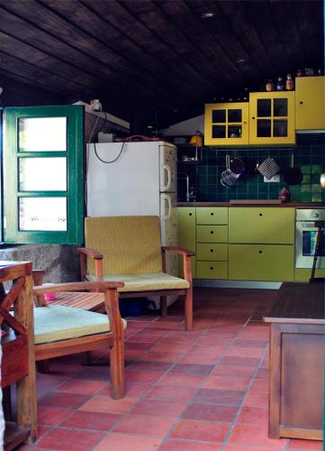 a kitchen with two chairs and a refrigerator at Casinha da Horta com Jacuzzi in Soajo