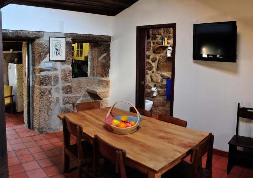 a wooden table with a basket of fruit on it at Casinha da Horta in Soajo