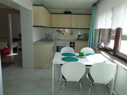 a kitchen with a white table and white chairs at Ferienwohnung "Am Recknitzhang" in Daskow