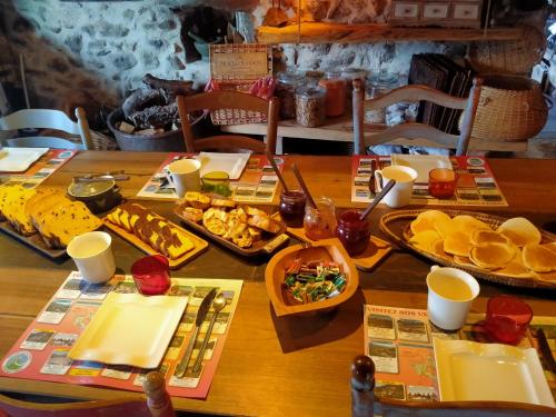 une table en bois avec des assiettes de nourriture dessus dans l'établissement Les Toits Rouges le luxe de la simplicité, à Saint-Étienne-de-Tinée