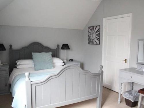 a bedroom with a bed and a clock on the wall at Frasers Battlesbridge in Battlesbridge