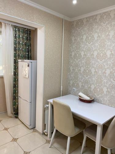 奇西瑙的住宿－Apartament Chisinau str.Cuza Voda，厨房配有白色的桌子和冰箱。