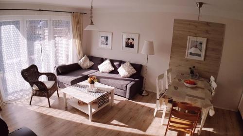 a living room with a couch and a table at Familienwohnung MANDO in Neue Tiefe Fehmarn