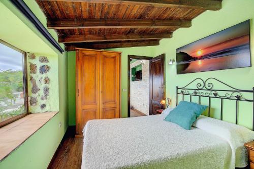 a bedroom with a large bed and a window at CASA RURAL LOS DRAGUITOS 2 in Santa Cruz de la Palma