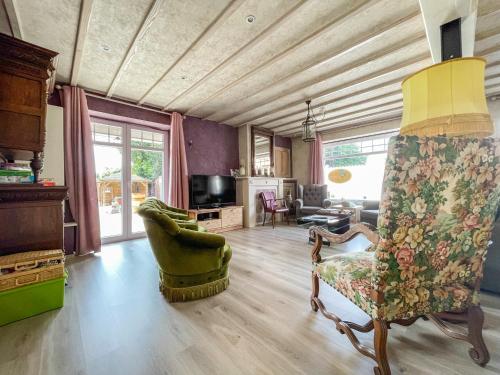 uma sala de estar com um sofá e uma cadeira em Luppolo vakantiehuis Westhoek em Alveringem