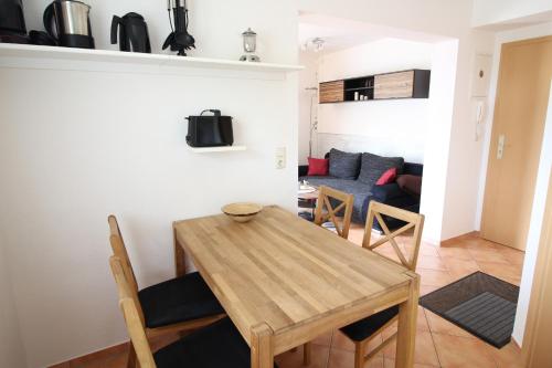 uma sala de jantar e sala de estar com mesa e cadeiras em Strandperle App 10 em Dierhagen